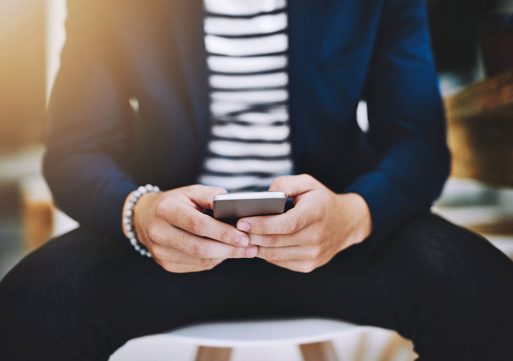 Två händer som använder en smartphone.