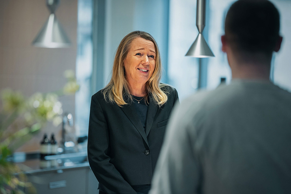 Kvinnlig medarbetare på Lärarnas a-kassa pratar med en kollega.